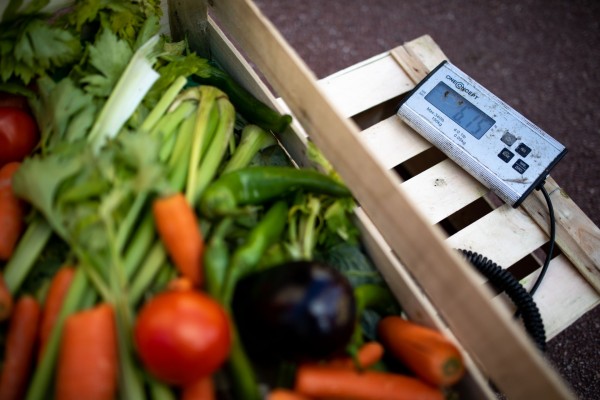 Une cagette de légumes en train d'être pesée