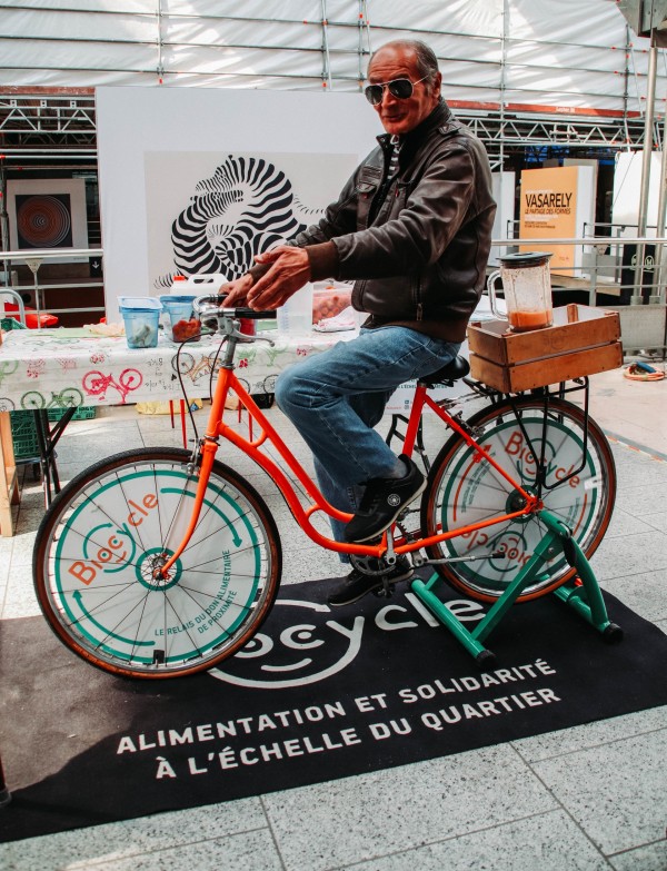 Un homme pédale sur notre vélo mixeur durant une animation de sensibilisation à l'anti-gaspi